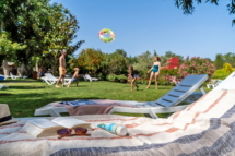 Camping Le Sérignan Plage, gezin speel op het gras naast het lagunebad